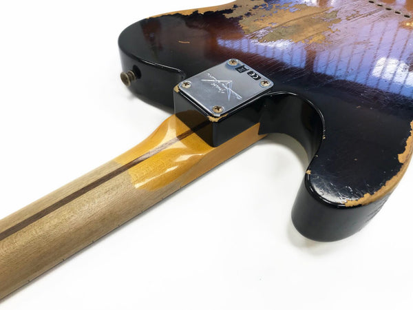 Close-up of worn black electric guitar body and maple neck with skunk stripe, showing vintage relic paint and chrome neck plate with screws, isolated on a white background.