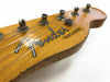 Close-up of worn Fender Telecaster guitar headstock with vintage tuning pegs and visible wood grain texture on natural finish