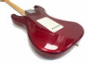 Glossy red electric guitar body with white backplate and maple neck shown from the rear on a white background