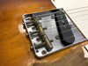 Close-up of vintage Fender Telecaster guitar bridge and pickup on worn natural wood finish body