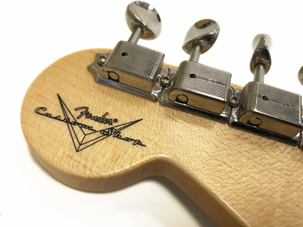 Close-up of Fender Custom Shop guitar headstock with chrome tuning pegs and natural wood finish