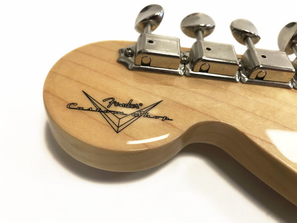 Close-up of Fender Custom Shop guitar headstock with tuning pegs and natural wood finish