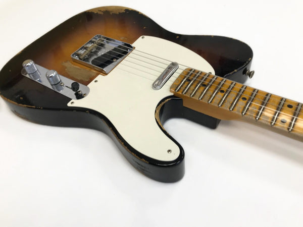 Vintage sunburst electric guitar with worn finish, chrome hardware, white pickguard, and maple neck on white background
