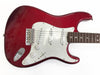 Red electric guitar with white pickguard and three single-coil pickups, rosewood fretboard, and chrome hardware on white background.