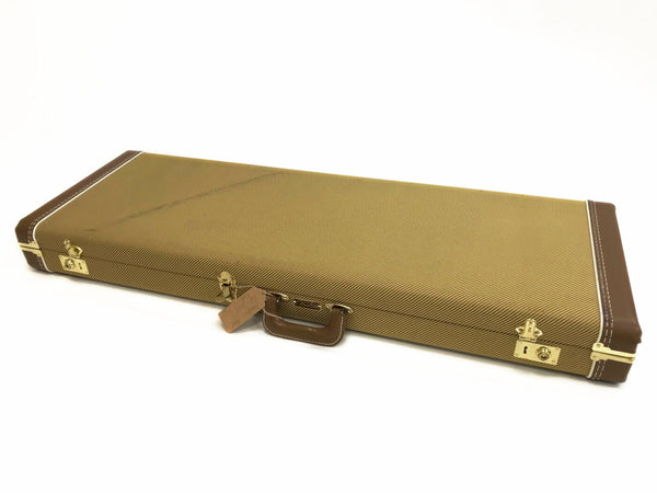 Rectangular vintage-style guitar case with brown leather corners and handle, gold-colored latches, and tweed fabric covering, designed for electric guitars.
