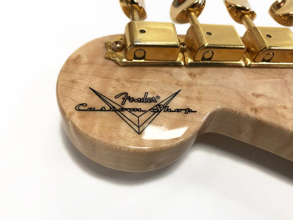 Close-up of Fender Custom Shop guitar neck heel with gold tuning machines and natural wood finish