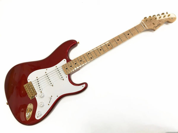 Fender Stratocaster electric guitar in red with white pickguard, maple fretboard, and gold hardware on white background