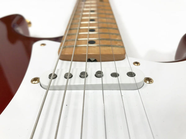 Close-up view of electric guitar strings, single-coil pickups, and maple fretboard with dot inlays on red and white body guitar from Coffee House Guitars