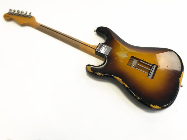 Vintage sunburst electric guitar with worn finish and missing strings, showing back view and metal neck plate on white background