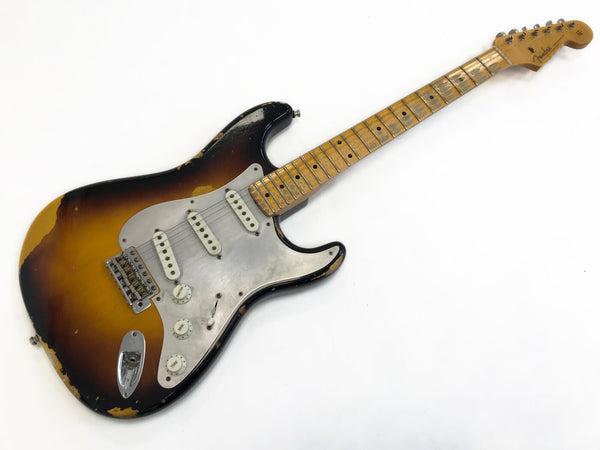 Vintage Fender Stratocaster electric guitar with sunburst finish and maple neck showing worn and aged wear on body and fretboard
