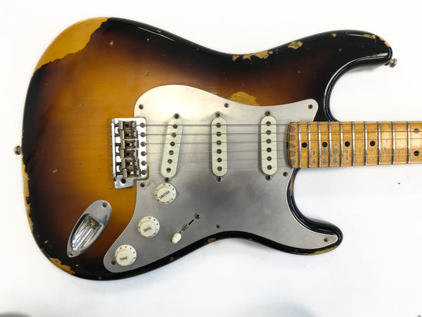 Vintage sunburst electric guitar with worn maple fretboard and metal pickguard showing heavy relic wear