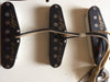 Close-up of vintage Fender Stratocaster single-coil pickups with cloth-covered wiring and handwritten markings on pickup covers.
