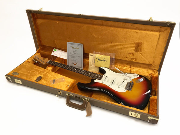 Vintage Fender Stratocaster electric guitar in sunburst finish inside tan hard case with certificate of authenticity and Fender cleaning cloth