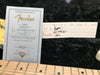 Fender Certificate of Authenticity for Stratocaster Pro Closet Classic guitar dated 08/31/06 with Fender Custom Shop tag and part number 3514 displayed on black plush background next to maple guitar fretboard.