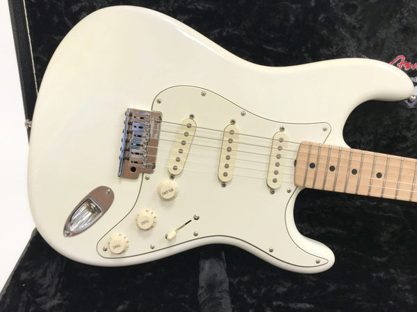 White electric guitar with maple fretboard and three single-coil pickups on black background