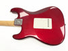 Back view of red electric guitar body with white backplate and natural wood neck, showing metal neck plate with serial number.