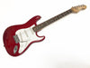 Red electric guitar with white pickguard, three single-coil pickups, tremolo bridge, maple neck, and rosewood fretboard on white background