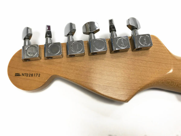 Close-up of natural wood guitar headstock with six chrome tuning pegs and serial number N7226172 on white background