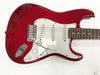 Red electric guitar with white pickguard, three single-coil pickups, tremolo arm, and rosewood fretboard on white background.