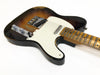 Vintage sunburst electric guitar with worn maple fretboard and white pickguard on white background