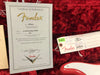 Fender Certificate of Authenticity for ’54 Stratocaster NOS with serial number 2032 and Fender Custom Shop tag on red plush guitar case lining.