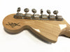 Back of Fender Custom Shop guitar headstock with six chrome tuning pegs on natural wood finish