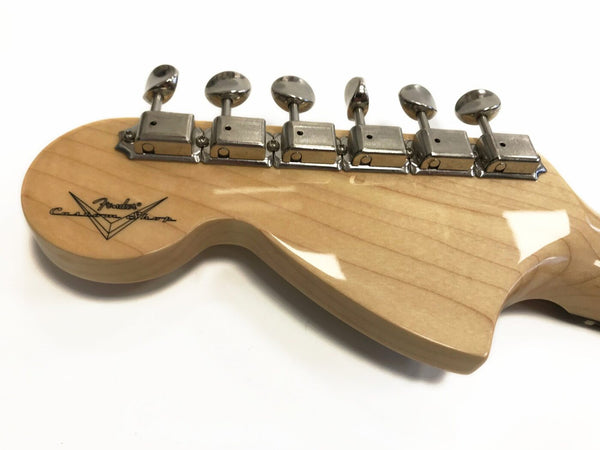 Back of Fender Custom Shop guitar headstock with six chrome tuning pegs on natural wood finish