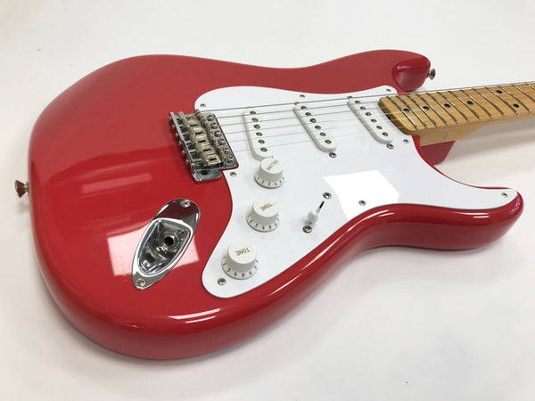 Red electric guitar with white pickguard, three single-coil pickups, maple neck, and chrome hardware on white background