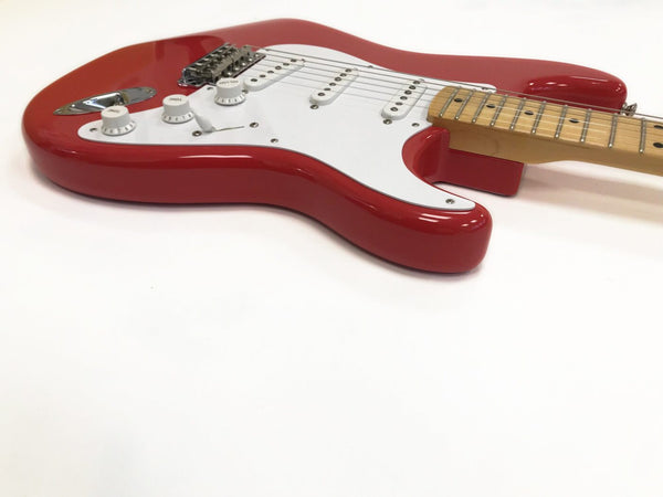 Close-up of red electric guitar with white pickguard and maple neck on white background, showcasing tone and volume control knobs and pickups