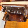 Close-up of guitar tremolo cavity showing springs and metal block inside an electric guitar body with wood grain finish