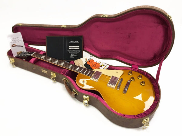 Gibson Les Paul electric guitar in sunburst finish inside open brown hardshell case with pink interior and included warranty and certificate documents