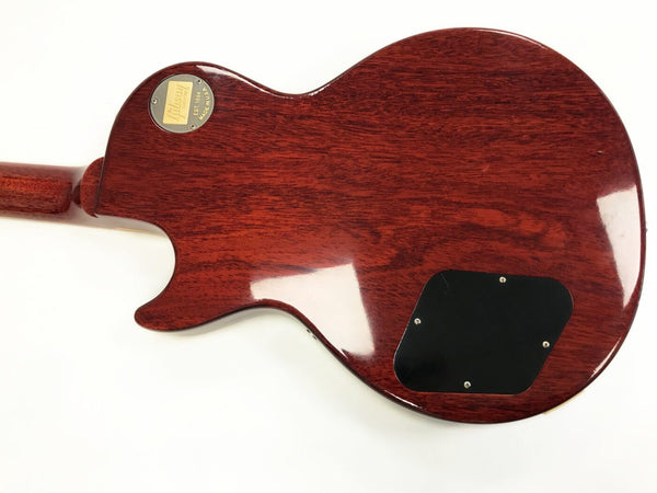 Back view of Gibson Les Paul electric guitar with mahogany wood body and plastic control cavity cover, featuring Gibson Custom Shop gold badge on the neck joint.
