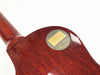 Close-up of the back of a Gibson Custom electric guitar showing the circular metal plate with Gibson Custom logo, "EST. 1894," and "MADE IN U.S.A." engraving on the polished mahogany wood body.