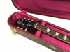 Gibson guitar headstock and neck with pearl inlays in pink velvet-lined hard case with gold latches
