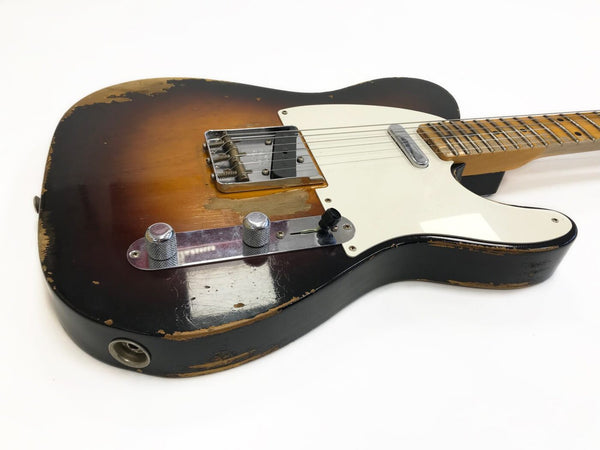 Vintage-style electric guitar with sunburst finish, white pickguard, and maple neck, showing worn and chipped paint details on a white background