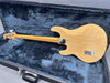 Vintage natural finish electric bass guitar with maple neck and four tuning pegs resting in fur-lined hard case