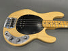 Vintage natural finish electric bass guitar with black pickguard and chrome control knobs on gray background