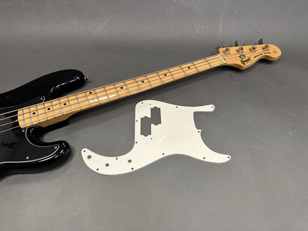 Greco Mercury Bass guitar with maple neck and fretboard in black finish next to a white replacement pickguard on gray background.