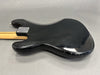 Black electric guitar body back with visible scratches and wear, maple neck with four-bolt neck plate on gray background