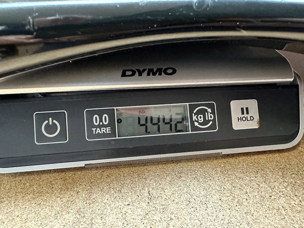 Digital DYMO scale showing weight of guitar frame at 4.442 pounds on wooden surface for Coffee House Guitars product listing.