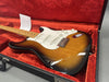 Electric guitar with sunburst finish and white pickguard in red velvet-lined hard case at Coffee House Guitars