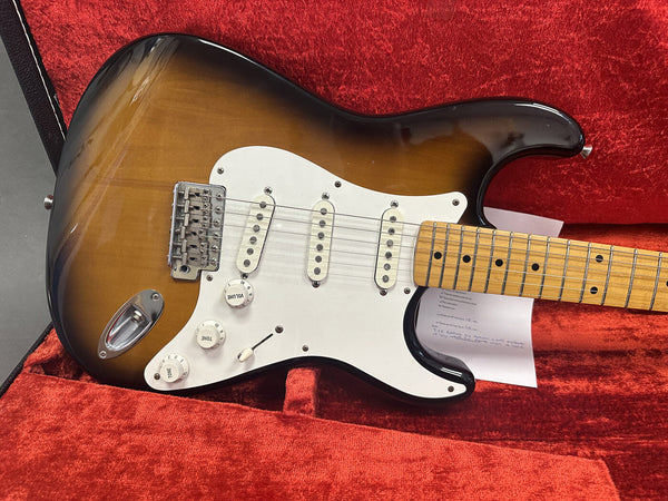 Sunburst electric guitar with white pickguard and maple neck in red velvet-lined case