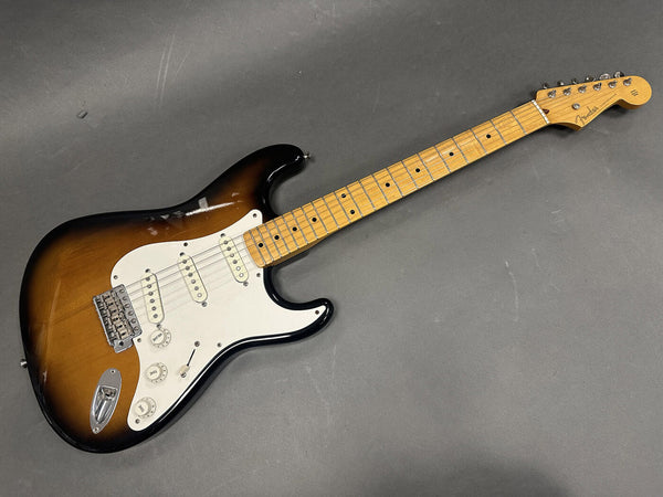 Fender Stratocaster electric guitar with sunburst finish, maple neck, and white pickguard on gray background