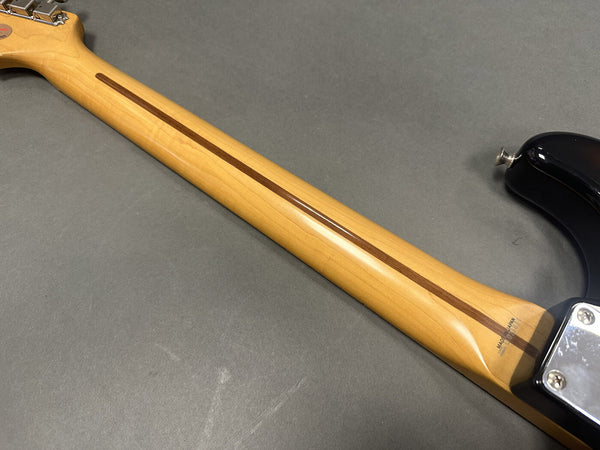 Close-up of maple neck with walnut skunk stripe on electric guitar, showing "Made in Japan" stamp near heel plate