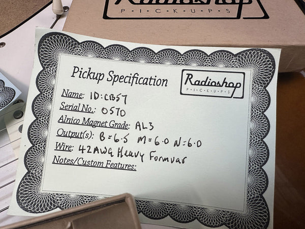 Radioshop pickup specification card with details including ID C1357, serial number 0570, Alnico magnet grade AL3, output levels B=6.5, M=6.0, N=6.0, and 42AWG heavy formvar wire.