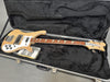 Rickenbacker electric bass guitar with natural wood finish and triangular fretboard inlays inside black plush-lined hard case