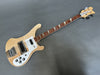 Rickenbacker electric bass guitar with natural wood finish, white pickguard, and distinctive triangle inlays on rosewood fretboard on gray background