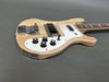 Natural wood finish electric bass guitar with white pickguard, chrome bridge, four control knobs, and two pickups on gray background