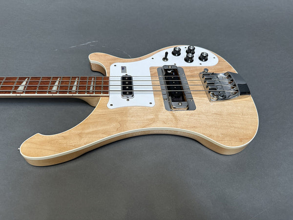 Natural finish electric bass guitar with rosewood fretboard, white pickguard, four control knobs, and chrome bridge on gray background