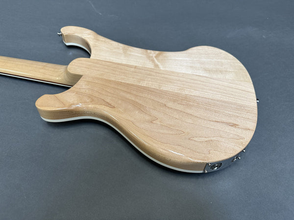 Back of natural wood electric guitar body with smooth, glossy finish on dark gray background